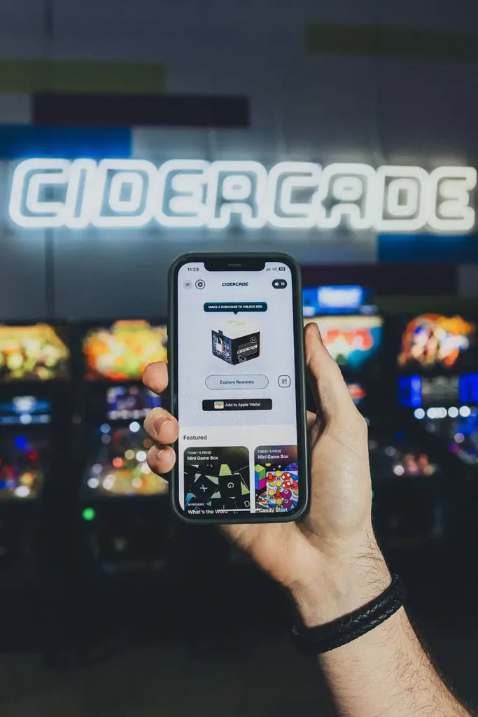 hand holding up the cidercade loyalty app on a phone