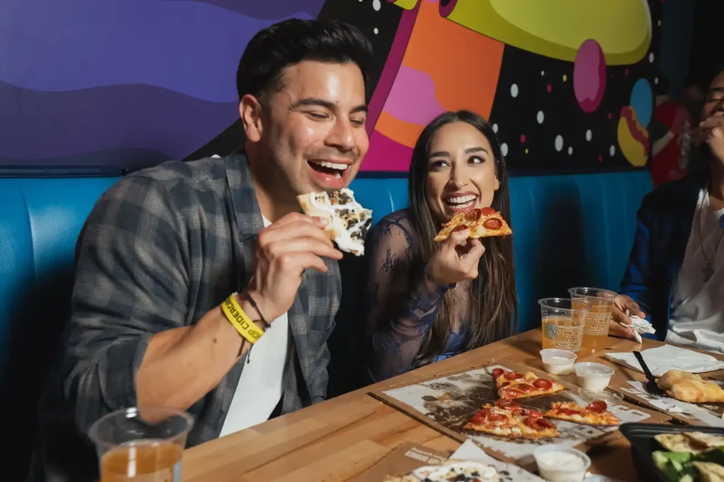 couple eating pizza at a table